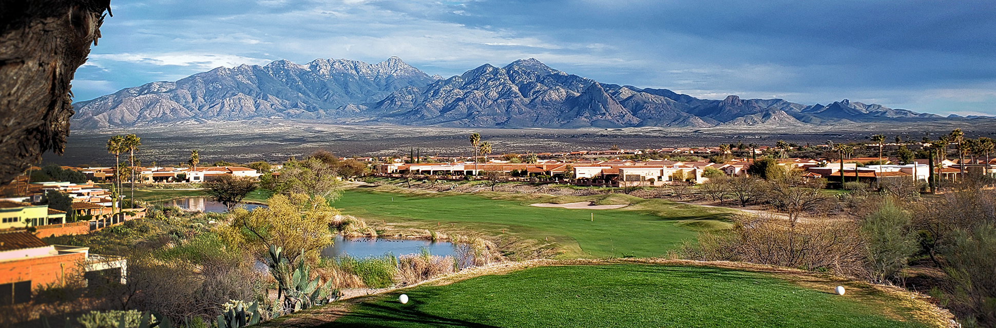 Aerial view of golf course with mountains in background